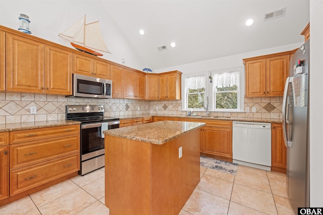 kitchen featuring visible vents, a sink, stainless steel appliances, light tile patterned flooring, and light stone countertops