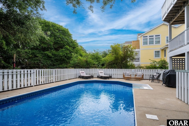 view of swimming pool featuring area for grilling, a patio, outdoor lounge area, and a fenced in pool