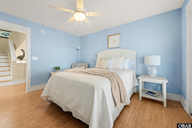 bedroom featuring ceiling fan, baseboards, and wood finished floors