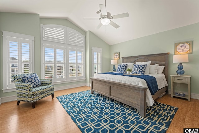 bedroom with baseboards, lofted ceiling, wood finished floors, and a ceiling fan