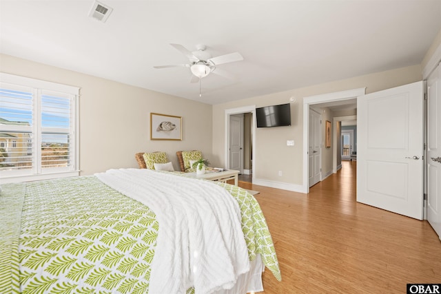 bedroom featuring light wood-type flooring, visible vents, baseboards, and a ceiling fan