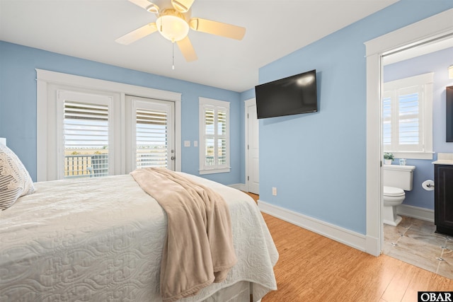 bedroom featuring access to outside, multiple windows, baseboards, and light wood-type flooring