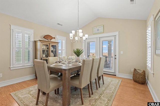 dining room with light wood-type flooring, visible vents, an inviting chandelier, baseboards, and vaulted ceiling