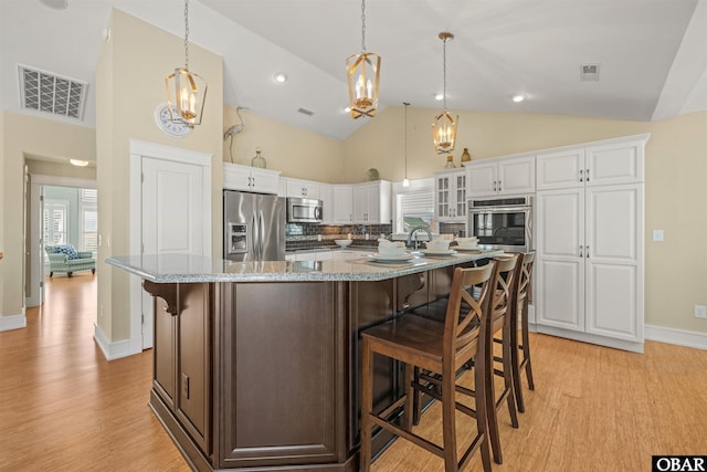 kitchen with white cabinetry, light wood-style floors, visible vents, and appliances with stainless steel finishes