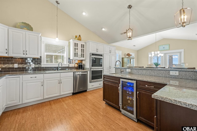 kitchen featuring a sink, light wood-style flooring, beverage cooler, and stainless steel appliances