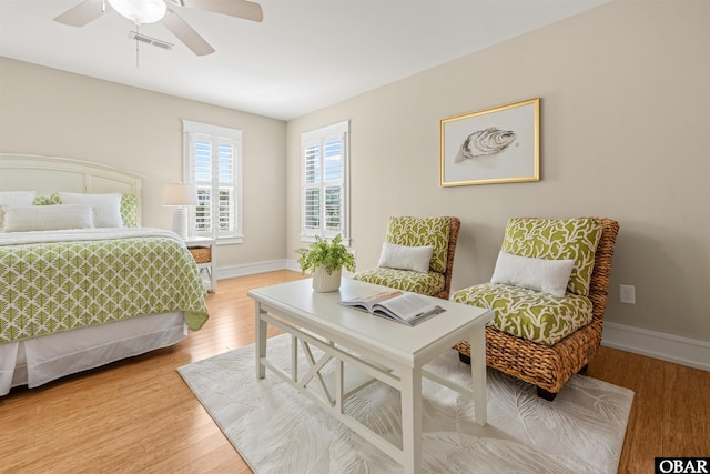 bedroom featuring visible vents, ceiling fan, baseboards, and wood finished floors