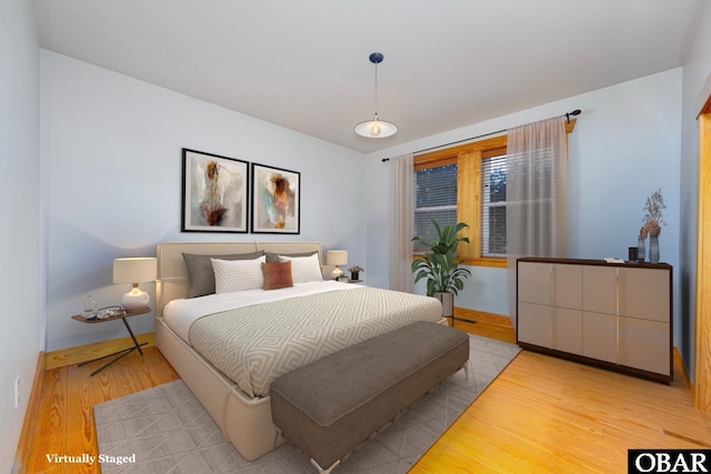 bedroom featuring baseboards and light wood finished floors