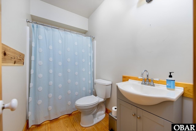 bathroom with vanity, wood finished floors, toilet, and a shower with curtain