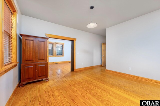 empty room featuring light wood-style flooring and baseboards