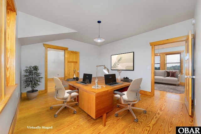 office area with light wood-type flooring, baseboards, and lofted ceiling