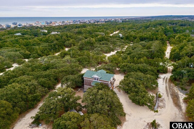 birds eye view of property featuring a forest view and a water view