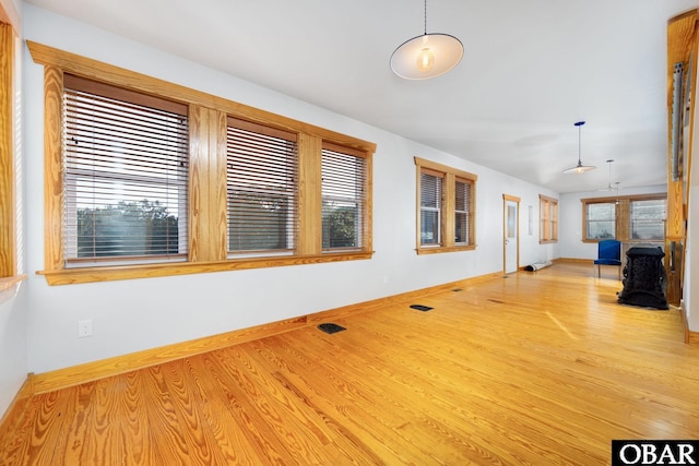 interior space featuring plenty of natural light, baseboards, and wood finished floors