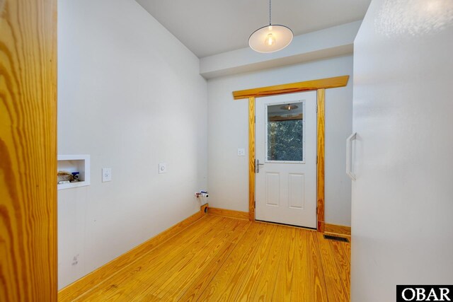 washroom with light wood-type flooring, washer hookup, baseboards, and laundry area