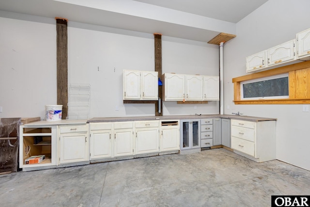 kitchen with concrete floors and white cabinets