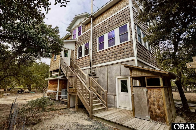 back of property featuring central AC unit and stairway