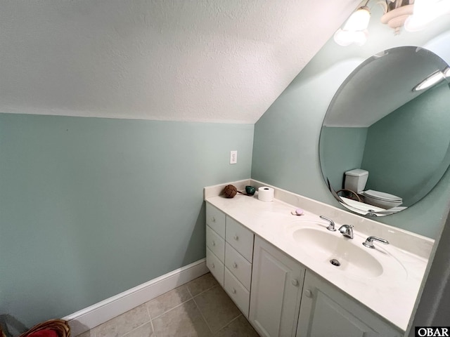 bathroom featuring a textured ceiling, lofted ceiling, vanity, baseboards, and tile patterned floors