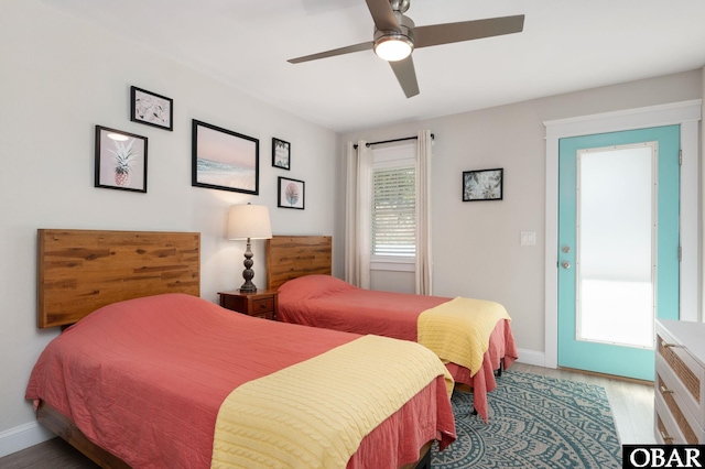 bedroom featuring ceiling fan, baseboards, and wood finished floors