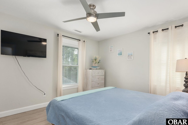 bedroom with visible vents, ceiling fan, baseboards, and wood finished floors