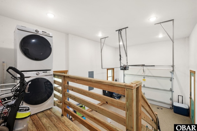 clothes washing area featuring stacked washer and dryer, laundry area, and recessed lighting