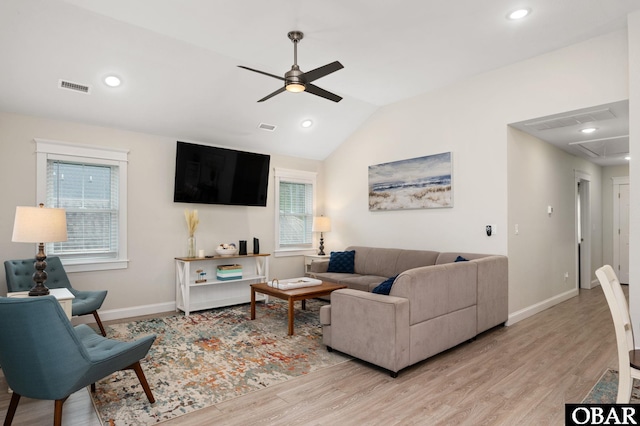 living area featuring visible vents, attic access, vaulted ceiling, light wood-type flooring, and baseboards