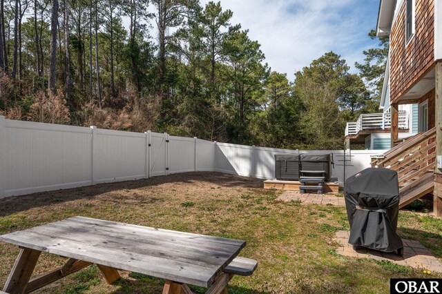 view of yard featuring a hot tub and a fenced backyard