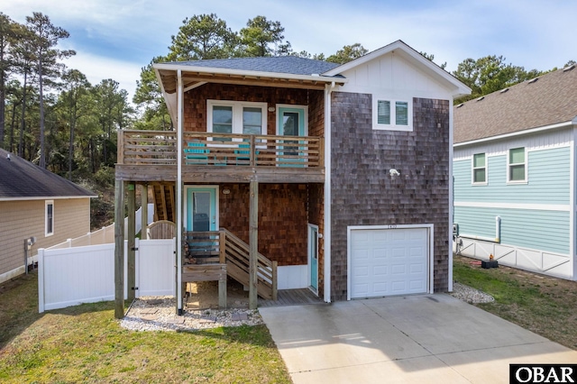 view of front of home featuring driveway, a shingled roof, an attached garage, fence, and a front yard