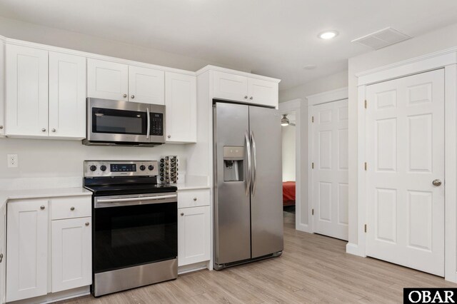 kitchen featuring visible vents, light wood-style floors, white cabinetry, light countertops, and appliances with stainless steel finishes