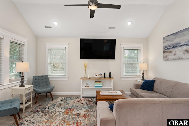 living room featuring visible vents, vaulted ceiling, and wood finished floors