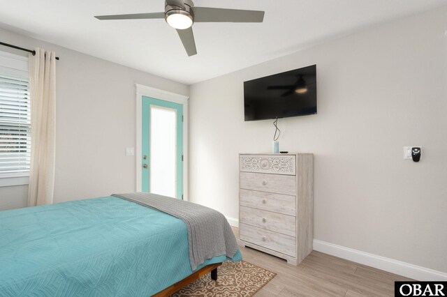 bedroom with ceiling fan, light wood finished floors, and baseboards