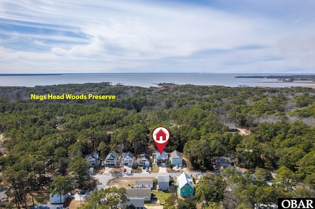 birds eye view of property featuring a water view and a view of trees