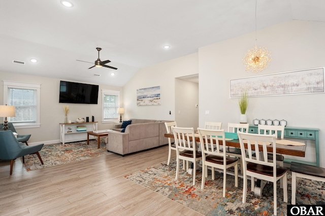 dining space with lofted ceiling, recessed lighting, visible vents, wood finished floors, and ceiling fan with notable chandelier