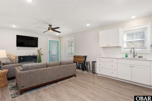 living room featuring light wood-type flooring, ceiling fan, and recessed lighting