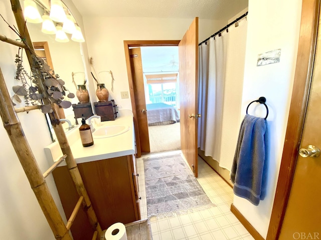 ensuite bathroom with connected bathroom, vanity, and tile patterned floors