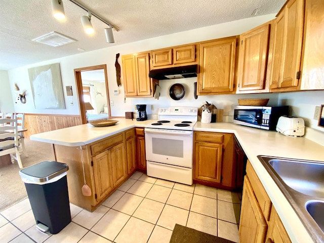 kitchen with under cabinet range hood, stainless steel microwave, light countertops, and white range with electric cooktop