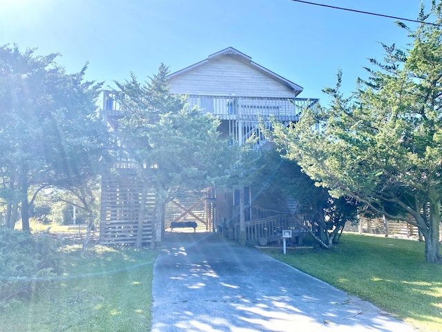 view of front of property featuring a front yard, driveway, and stairs