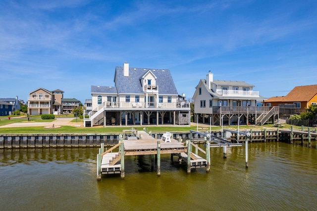 view of dock with a yard, a deck with water view, and stairs