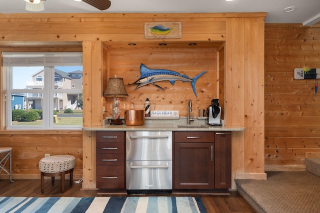 bar featuring wood walls and a sink