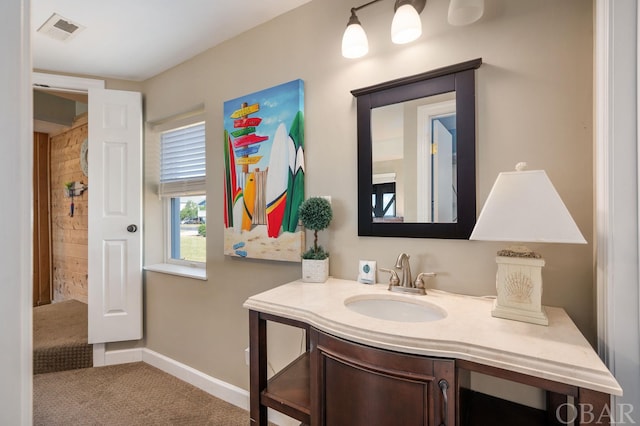 bathroom featuring vanity, visible vents, and baseboards