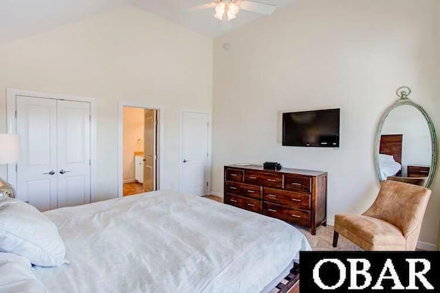 bedroom with ensuite bath, ceiling fan, high vaulted ceiling, and a closet