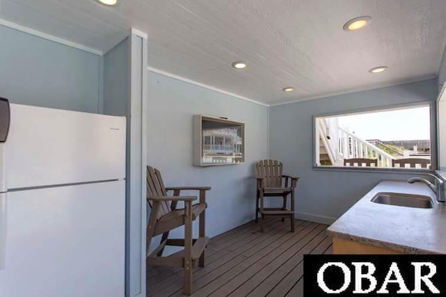 kitchen featuring freestanding refrigerator, a sink, hardwood / wood-style floors, and recessed lighting