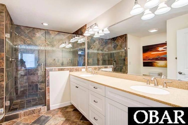 bathroom with double vanity, a stall shower, and a sink