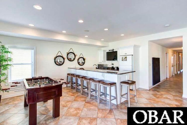 recreation room with recessed lighting and baseboards