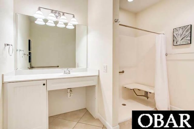 full bath featuring a shower with shower curtain, a sink, tile patterned flooring, and baseboards