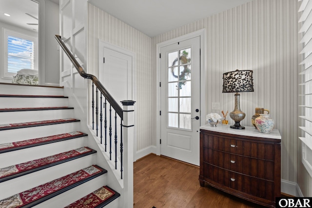 entrance foyer with wallpapered walls, stairs, baseboards, and wood finished floors