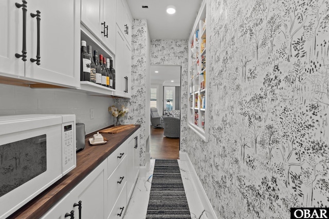 bar featuring wallpapered walls and white microwave