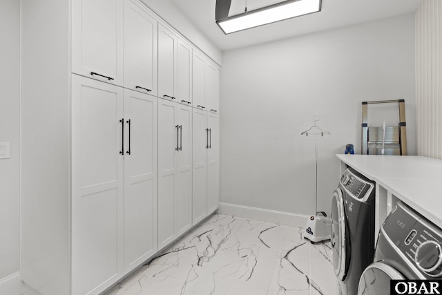 washroom featuring cabinet space, baseboards, marble finish floor, and independent washer and dryer