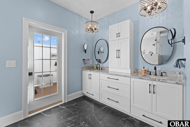 full bath featuring marble finish floor, a notable chandelier, baseboards, and a sink