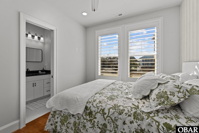 bedroom featuring dark wood-type flooring, connected bathroom, and visible vents