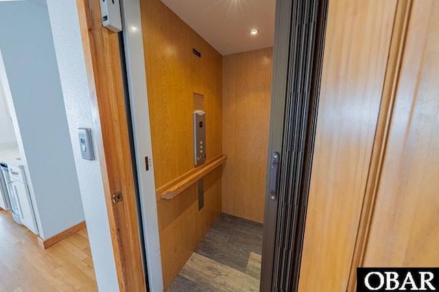 hallway featuring elevator and wood finished floors
