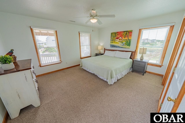 bedroom featuring a ceiling fan, visible vents, light colored carpet, and baseboards